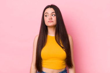 Genç bir kadın merak ediyor, mutlu düşünceler ve fikirler düşünüyor, hayal kuruyor, kenarda yer arıyor.