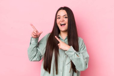 Genç bir kadın sevinçli ve şaşırmış hissediyor. Şok olmuş bir ifadeyle gülümsüyor.