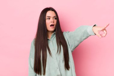 Genç bir kadın şaşkın ve şaşırmış hissediyor, şaşkınlık içinde hayranlıkla bakıyor ve ona bakıyor.