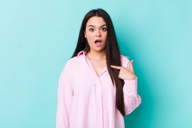 Şok olmuş ve şaşırmış genç bir kadın ağzı açık, kendini işaret ediyor.