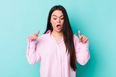 Genç bir kadın şok olmuş, ağzı açık ve şaşırmış hissediyor. İnançsızlık ve şaşkınlık içinde bakıyor ve onu işaret ediyor.