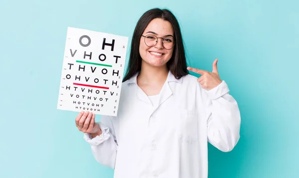 young adult woman smiling confidently pointing to own broad smile. optical vision test concept