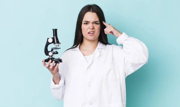 young adult woman feeling confused and puzzled, showing you are insane. scientist concept