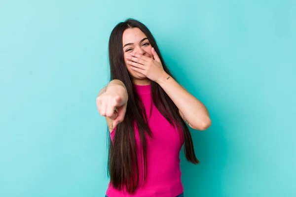 young adult woman laughing at you, pointing to camera and making fun of or mocking you