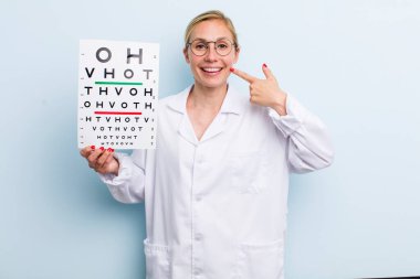 Genç, sarışın, kendine güvenen ve gülümseyen bir kadın. optik görüş testi konsepti