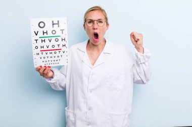 Genç sarışın kadın sinirli bir ifadeyle agresif bir şekilde bağırıyor. optik görüş testi konsepti