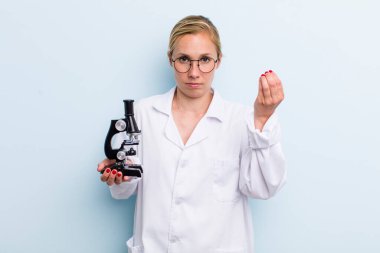 Genç sarışın kadın kapiş ya da para hareketi yapıyor, sana ödemeni söylüyor. Mikroskop konseptine sahip bilim adamı