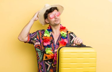 Kafası karışmış, kafası karışmış, kaşınan genç yakışıklı bir adam. Yaz tatili konsepti