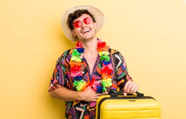 Genç yakışıklı adam komik bir şakaya yüksek sesle gülüyor. Yaz tatili konsepti