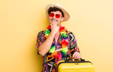 Genç, yakışıklı, mutlu, kendine güvenen ve elleri çenesinde gülümseyen adam. Yaz tatili konsepti