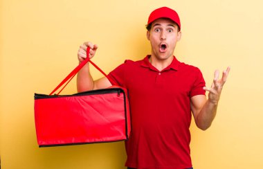 Genç ve yakışıklı adam şok olmuş ve şaşırmış hissediyor. Pizza teslimatı kavramı
