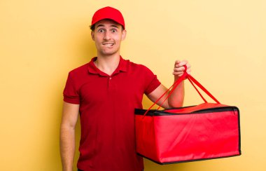 Genç ve yakışıklı adam kafası karışmış ve şaşkın görünüyor. Pizza teslimatı kavramı