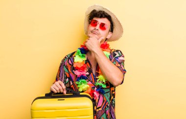 Genç yakışıklı adam düşünüyor, kuşkulu ve şaşkın hissediyor. Yaz tatili konsepti