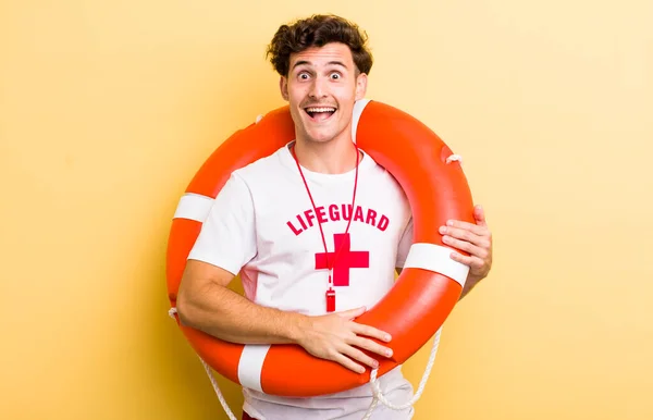young handsome guy looking happy and pleasantly surprised. lifeguard concept