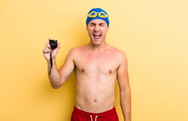 Genç yakışıklı adam agresif bir şekilde bağırıyor, çok kızgın görünüyor. yüzücü kavramı