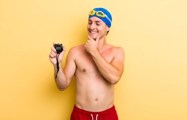 Genç, yakışıklı, mutlu, kendine güvenen ve elleri çenesinde gülümseyen adam. yüzücü kavramı