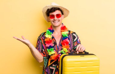 Genç yakışıklı adam neşeyle gülümsüyor, mutlu hissediyor ve bir konsept gösteriyor. Yaz tatili konsepti