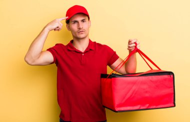 Genç yakışıklı, kafası karışık ve şaşkın hissediyor, sana deli olduğunu gösteriyor. Pizza teslimatı kavramı