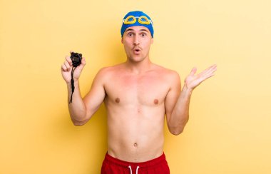Genç, yakışıklı adam şaşırmış ve şok olmuş görünüyor. Çenesi düşmüş, elinde bir nesne var. yüzücü kavramı