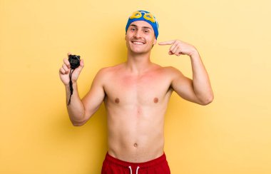 Genç ve yakışıklı adam, kendine güvenerek gülümsüyor. yüzücü kavramı