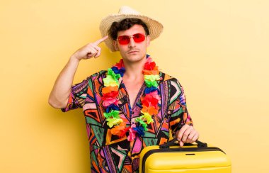 Genç yakışıklı, kafası karışık ve şaşkın hissediyor, sana deli olduğunu gösteriyor. Yaz tatili konsepti