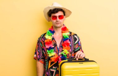 Genç yakışıklı adam üzgün, üzgün ya da kızgın hissediyor ve yana bakıyor. Yaz tatili konsepti