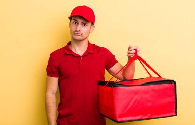 Genç yakışıklı adam şaşkın ve şaşkın hissediyor. Pizza teslimatı kavramı