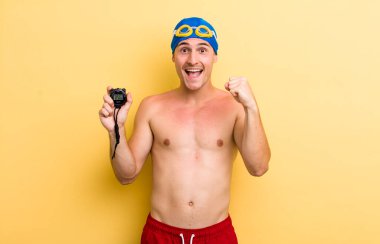 Genç yakışıklı adam şok olmuş hissediyor, gülüyor ve başarıyı kutluyor. yüzücü kavramı