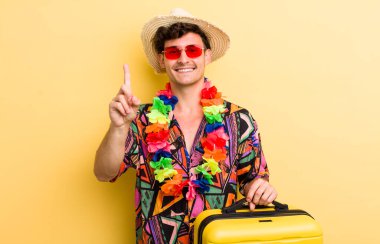 Genç yakışıklı adam gülümsüyor ve arkadaş canlısı görünüyor, bir numarayı gösteriyor. Yaz tatili konsepti