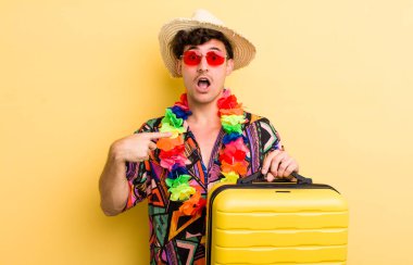 Şok olmuş ve ağzı açık, kendini işaret eden genç ve yakışıklı bir adam. Yaz tatili konsepti