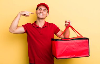 Genç ve yakışıklı adam, kendine güvenerek gülümsüyor. Pizza teslimatı kavramı
