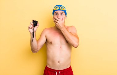 Genç ve yakışıklı adam elleri ile ağzını kapatıyor ve şoka giriyor. yüzücü kavramı