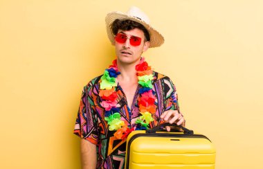 Genç yakışıklı adam şaşkın ve şaşkın hissediyor. Yaz tatili konsepti