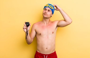 Genç yakışıklı adam mutlu bir şekilde gülümsüyor ve hayal kuruyor ya da şüphe ediyor. yüzücü kavramı