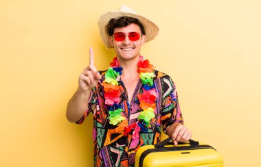 Genç yakışıklı adam gururla gülümsüyor ve kendinden emin bir numara oluyor. Yaz tatili konsepti