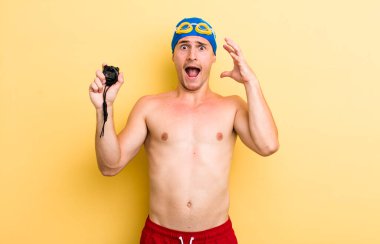 Genç yakışıklı adam ellerini havaya kaldırarak çığlık atıyor. yüzücü kavramı