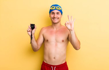 Genç yakışıklı adam kendini mutlu hissediyor, iyi bir jestle onaylıyor. yüzücü kavramı