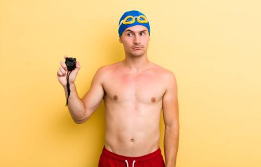 Genç yakışıklı adam üzgün, üzgün ya da kızgın hissediyor ve yana bakıyor. yüzücü kavramı