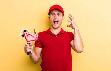 Genç yakışıklı adam ellerini havaya kaldırarak çığlık atıyor. Packer employee kavramı