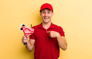 Genç yakışıklı adam kendini mutlu hissediyor ve heyecanla kendini işaret ediyor. Packer employee kavramı