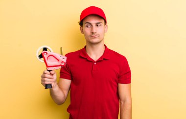 Genç yakışıklı adam üzgün, üzgün ya da kızgın hissediyor ve yana bakıyor. Packer employee kavramı