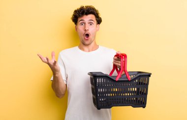 Genç yakışıklı adam inanılmaz bir sürprizle şaşkına dönmüş ve hayrete düşmüştü. boş alışveriş sepeti kavramı