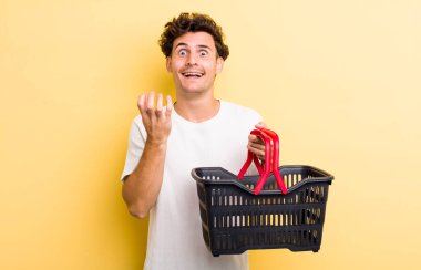 Genç ve yakışıklı adam umutsuz, sinirli ve stresli görünüyor. boş alışveriş sepeti kavramı