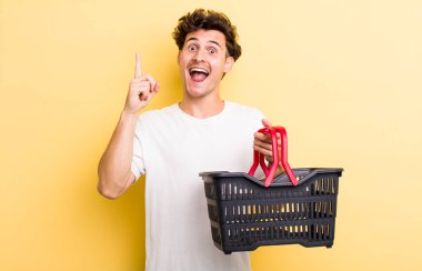 young handsome guy feeling like a happy and excited genius after realizing an idea. empty shopping basket concept clipart