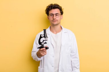 Genç yakışıklı adam üzgün, üzgün ya da kızgın hissediyor ve yana bakıyor. Bilim öğrencisi konsepti