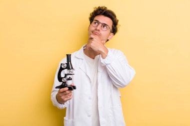 Genç yakışıklı adam düşünüyor, kuşkulu ve şaşkın hissediyor. Bilim öğrencisi konsepti