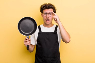 Genç yakışıklı adam şaşırmış görünüyor, yeni bir düşünce, fikir ya da konsept fark ediyor. Şefin tava konsepti.