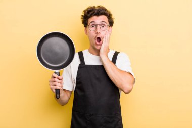 Genç ve yakışıklı adam şok olmuş ve korkmuş hissediyor. Şefin tava konsepti.