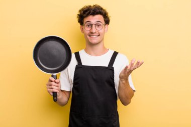 Genç yakışıklı adam kendini mutlu hissediyor, bir çözüm ya da fikir bulduğuna şaşırıyor. Şefin tava konsepti.