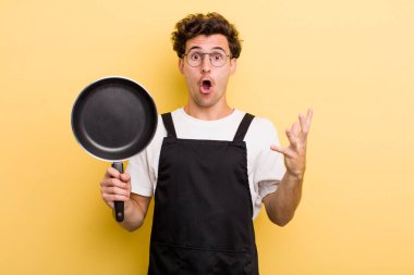 Genç ve yakışıklı adam şok olmuş ve şaşırmış hissediyor. Şefin tava konsepti.